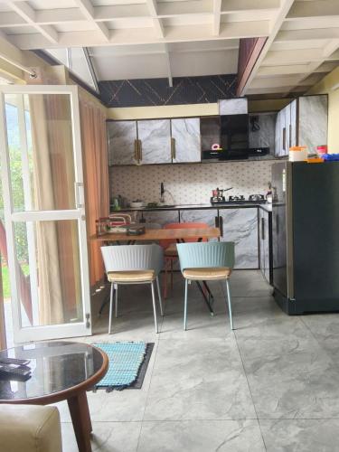 a kitchen with a table and chairs in a room at Mount Homestay in Nedukandam