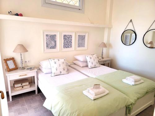 a bedroom with two beds and a mirror at PHILIPPOS 2 in Diaporos