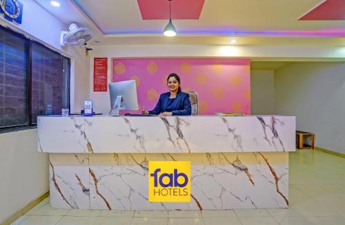 a woman sitting at a counter in an office at FabHotel Wagholi Inn in Pune
