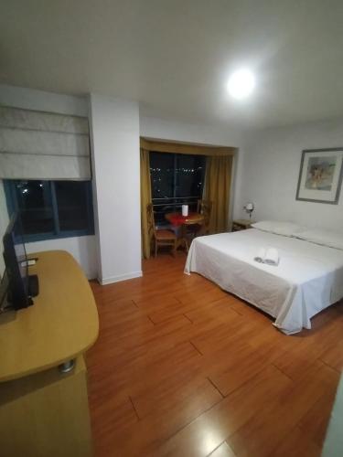 a bedroom with a bed and a table and a desk at Apartamento Star in Mendoza