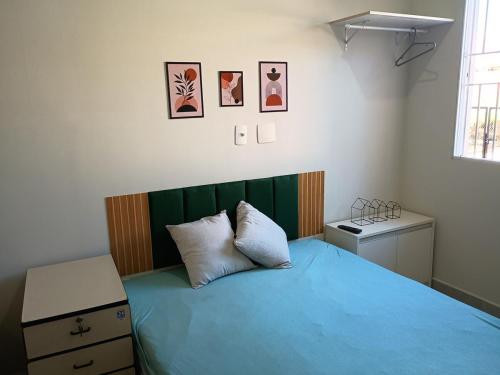 a bedroom with a bed with blue sheets and a table at Parque Ecológico - Studio 3 - Térreo in Indaiatuba