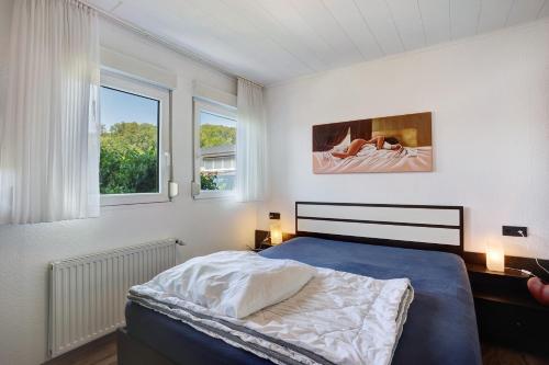 a bedroom with a bed and two windows at Ferienhaus Bianca in Meschede