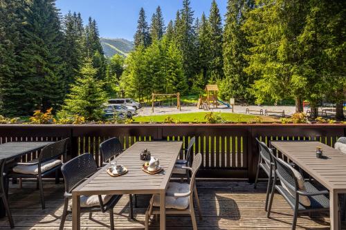 a deck with tables and chairs and a playground at Hotel Mikulášska Chata in Belá