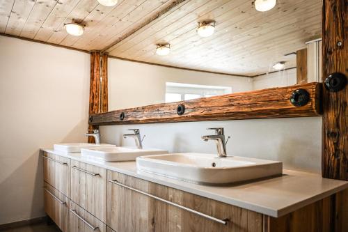 a bathroom with two sinks and a mirror at Berghof Papstdorf in Kurort Gohrisch