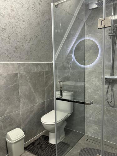 a bathroom with a toilet and a glass shower at lovelaz820 in Khashchovanoye
