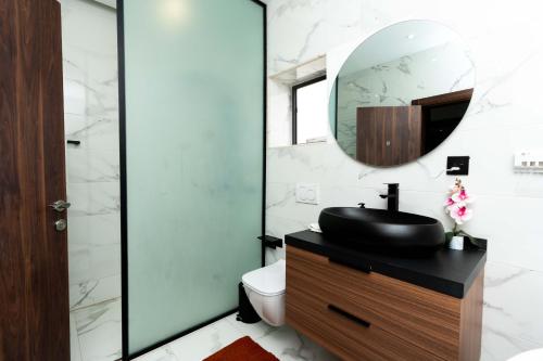a bathroom with a sink and a mirror at Luxury Executive Balcony Suite at THE HIDDEN DOMUS I Elmina Suite in Accra