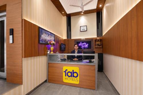 a woman sitting at a counter in a hotel lobby at FabHotel Amar Residency, Sector 7, Dwarka in New Delhi