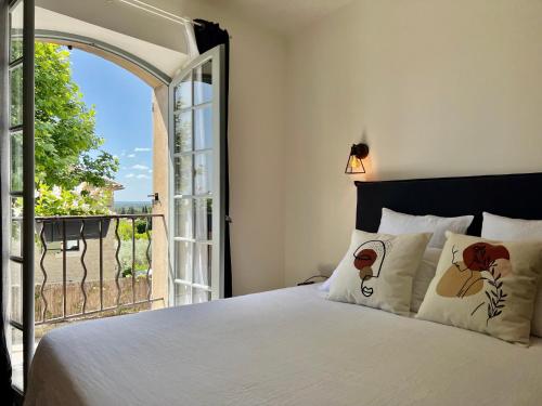 a bedroom with a bed and an open window at La Villa 1777 in Lagnes
