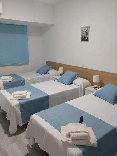 a room with four beds with towels on them at Hostal el Olivo in Mora