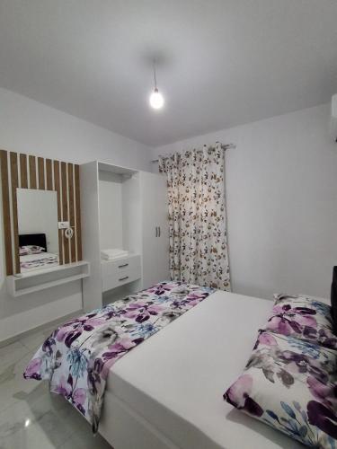 a bedroom with a large bed and a curtain at Sunset Bliss Apartments in Sarandë