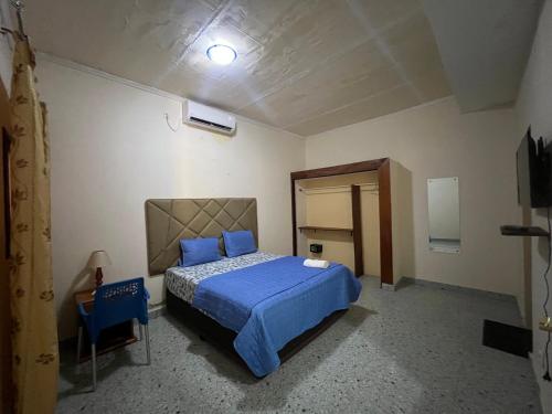 a bedroom with a blue bed and a blue chair at Hotel Residencial Assamar in Pemba