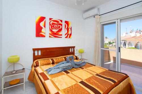 a bedroom with a bed with two paintings on the wall at CH Logroño Doña Pepa in Rojales