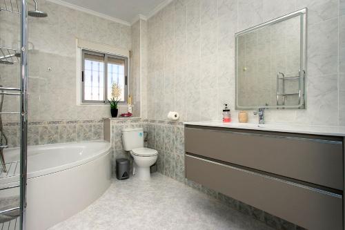 a bathroom with a tub and a toilet and a sink at CH Logroño Doña Pepa in Rojales