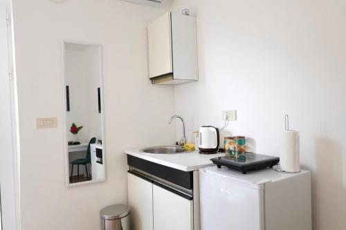 a white kitchen with a sink and a refrigerator at Doricera in Kotor