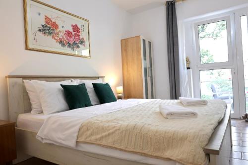 a bedroom with a large bed with green and white pillows at Doricera in Kotor
