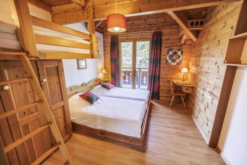 a bedroom with a bed in a wooden cabin at Chalet Le Serre des Oiseaux in Saint-Chaffrey