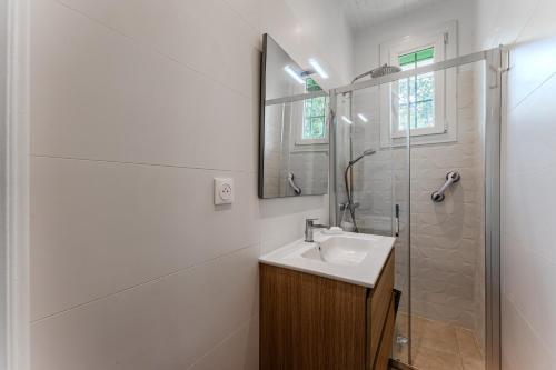 a white bathroom with a sink and a shower at Maison de Charme in Mimizan-Plage