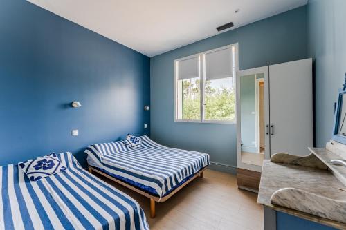 two beds in a room with blue walls at Maison de Charme in Mimizan-Plage