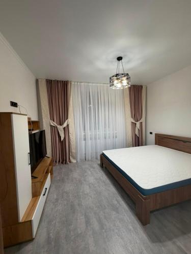 a bedroom with a bed and a flat screen tv at Kol-Ukok Hotel in Bol'shevik