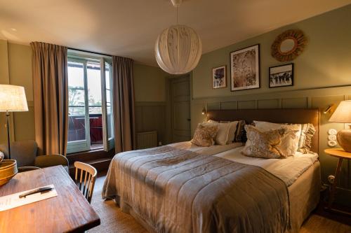 a hotel room with a large bed and a table at Fågelbro Säteri in Värmdö