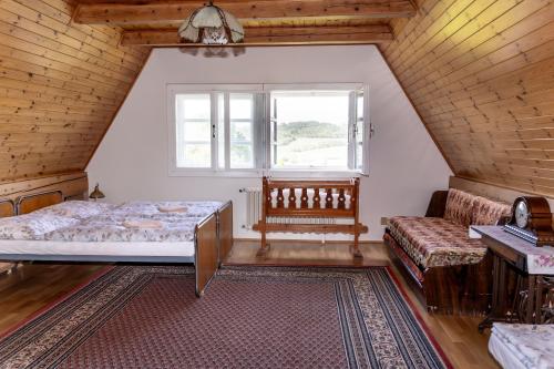 a bedroom with a bed and a couch and a window at Vila Vlasta in Bruntál