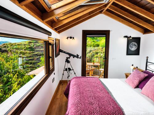 a bedroom with a bed and a large window at Los Nacientes Vega in Los Sauces