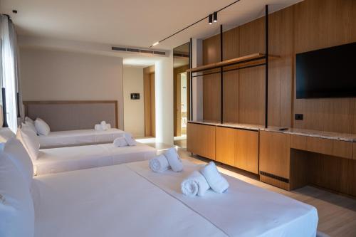 a hotel room with two beds and a flat screen tv at South Inn Marina Hotel in Vlorë