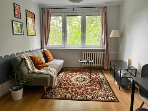 a living room with a couch and a window at Przytulne mieszkanie blisko morza in Gdańsk