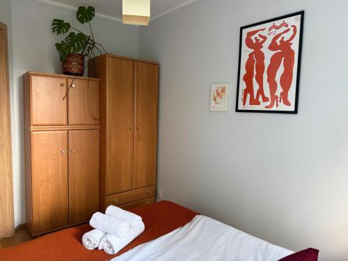 a bedroom with a bed and a wooden cabinet at Przytulne mieszkanie blisko morza in Gdańsk