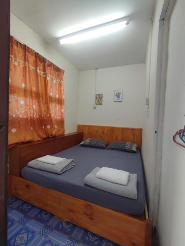 a bedroom with a wooden bed with towels on it at IDZ Jb ISLAM House in Kampong Kundassan