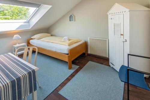 a small bedroom with a bed and a window at Ferienhaus Mackeriege in Norden