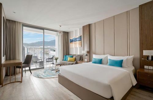 a bedroom with a large bed and a living room at Panorama Beach Win Nha Trang in Nha Trang