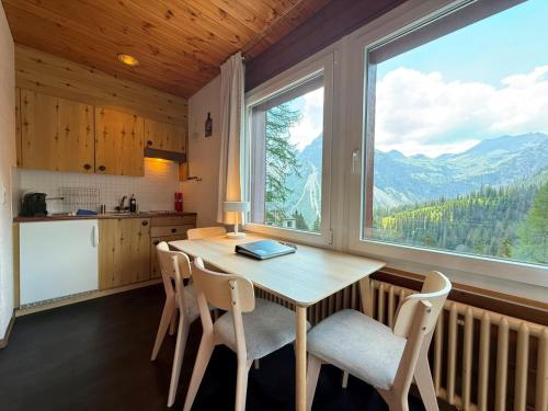 a kitchen with a table and chairs and a large window at Miraflor Sonja by Arosa Holiday in Arosa