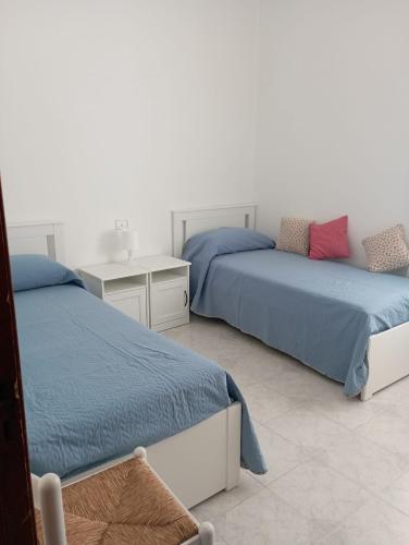 a bedroom with two beds and a desk at Una Terrazza sul mare in San Ferdinando