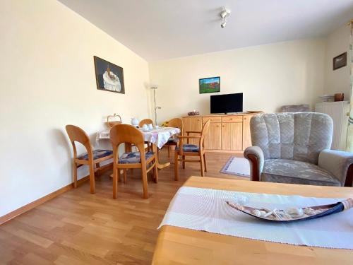 a living room with a table and chairs and a couch at Ferienwohnung Marianne 26835 Neukamperfehn in Neukamperfehn