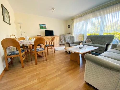 a living room with a couch and a table and chairs at Ferienwohnung Marianne 26835 Neukamperfehn in Neukamperfehn