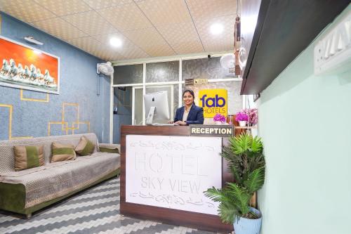 a woman standing behind a reception desk in a hotel sky view at FabHotel Skyview in Bhopal