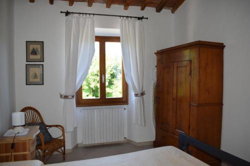 a bedroom with a window and a table and a chair at Martini River House in Barberino di Mugello