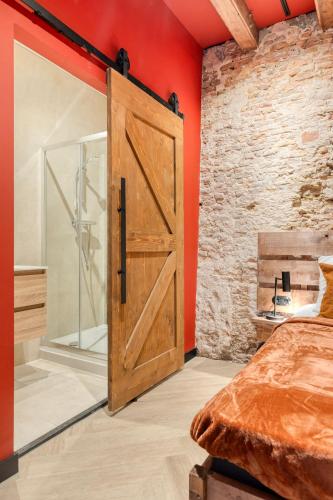 a bedroom with a wooden door and red walls at Boutique Hotel Alkmaar - City Rooms & Apartments in Alkmaar