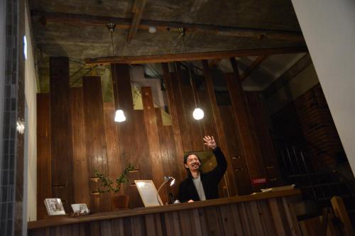 a woman is waving in front of a mirror at The Deer Park Inn in Nara