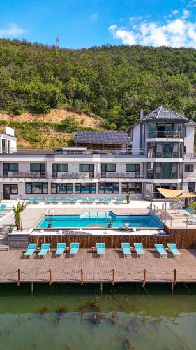 a large building with a pool and chairs in the water at CASA 9 - villa & spa in Eşelniţa