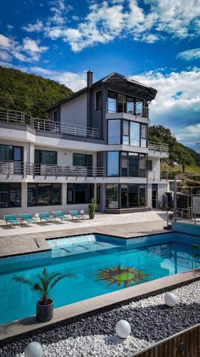 a large house with a swimming pool in front of it at CASA 9 - villa & spa in Eşelniţa