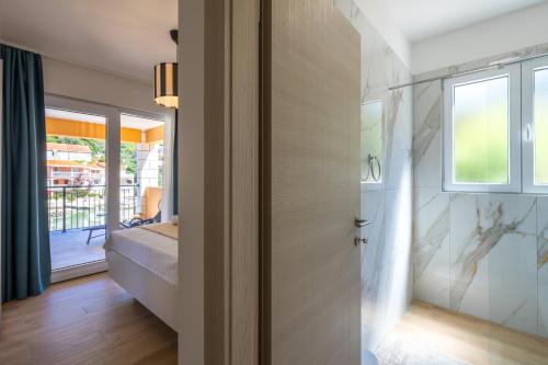 a bathroom with a door leading to a bedroom at Apartment Jakov Grscica in Prizba