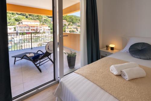 a bedroom with a bed and a balcony with a chair at Apartment Jakov Grscica in Prizba