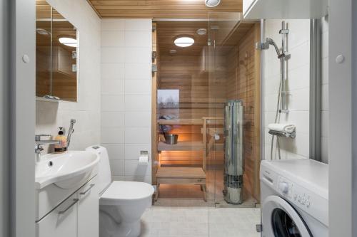 a bathroom with a shower and a toilet and a sink at Hiisi Homes Järvenpää in Järvenpää