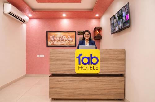 a woman standing behind a reception desk with a laptop at FabHotel Aqueens Plaza - Near Jawahar Circle, Patrika Gate in Siroli