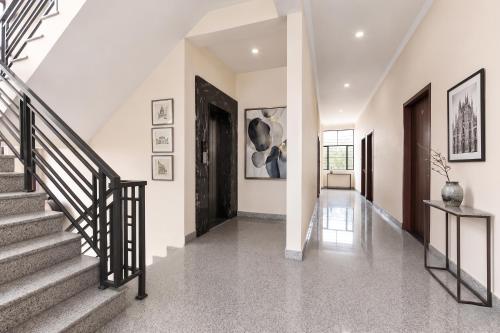 a staircase in a home with white walls and a black door at FabHotel Aqueens Plaza - Near Jawahar Circle, Patrika Gate in Siroli