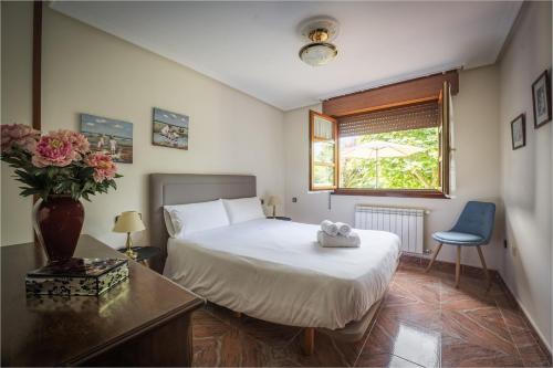 a bedroom with a bed and a vase of flowers at Casa Rural El FerJo in Colunga