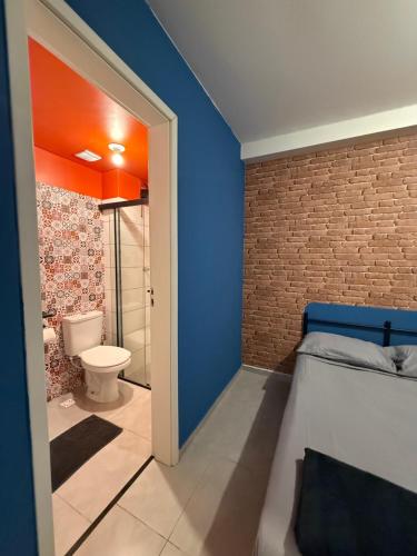 a bathroom with a bed and a toilet in a room at Apartamento Parque Trianon Exclusive in Araçatuba