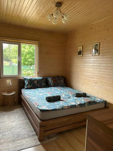a bedroom with a bed in a wooden room at Agroturystyka nad Jeziorem Orłowskim in Wielgie